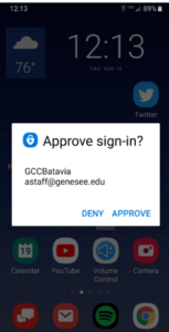 A sample mobile phone screen is shown, illustrating how the Microsoft Authenticator pop-up dialog will appear. The dialog reads: "Approve sign-in? GCCBatavia, astaff@genesee.edu, DENY, APPROVE."